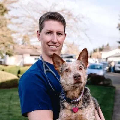 A Four Corners veterinarian outside the clinic with a heeler mix